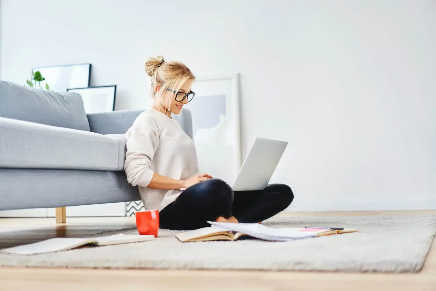 woman sitting on floor focusing on laptop